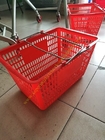 Τα κόκκινα εύκαμπτα χρησιμοποιημένα πλαστικά καλάθια αγορών με το κυρτό μέταλλο χειρίζονται/το χέρι πιασιμάτων
